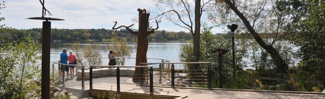 Two people at a lake enjoying the scenery and another person taking a photograph